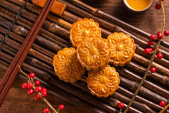中国传统糕点月饼月饼与茶杯在竹盘上的木背景中秋节，顶视图，平铺.