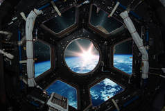 迷人的日出在地球上。太空船窗口视图。元素