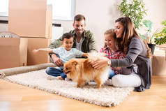 一家四口之家带着他们的宠物狗在新分离人的地毯上