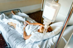 盐水滴袋挂在一个病人的床上.