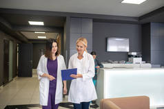 两名女医生在诊所走廊里交谈