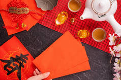 中国农历新年的设计理念- -妇女持仓，送红包（红包，红包）以换取好运，顶视图，平铺，头顶上方。春这个词意为春天来了.