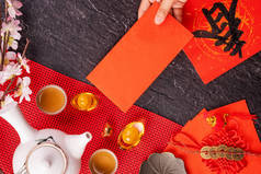 中国农历新年的设计理念- -妇女持仓，送红包（红包，红包）以换取好运，顶视图，平铺，头顶上方。春这个词意为春天来了.