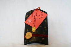 黑色和红色礼品盒，装有金黄色螺母壳和