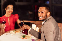 快乐的情侣们在餐馆里举杯庆祝情人节