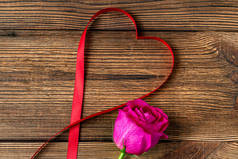 心形带子和粉色背景上的花 情人节礼物