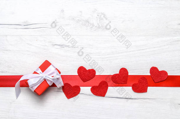 红丝带红心红丝礼品盒，白色木制背景白色丝带