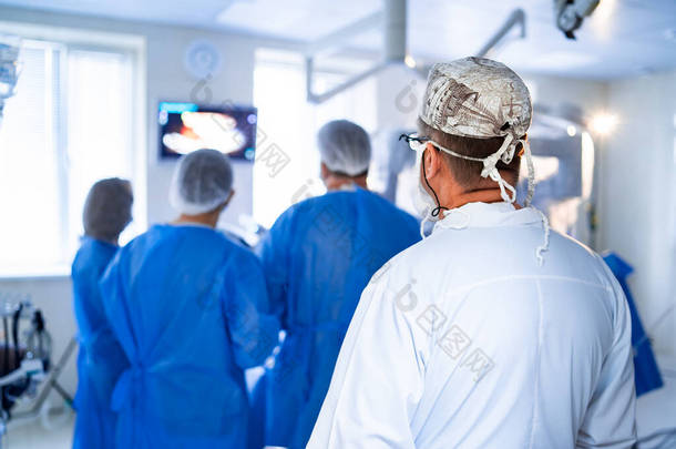 医疗队在明亮的现代手术室进行外科手术.手术室。诊所的现代设备。急救室.