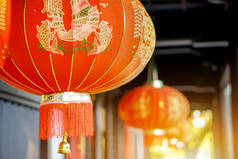 中国的红色灯笼挂在古寺顶，背景模糊不清，阳光灿烂。 2.中文灯笼上的字母在英语中是吉祥的恭维话.