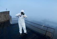 一名身穿防护服的科学家持适当设备在建筑物屋顶上就环境污染问题进行的全面科学研究