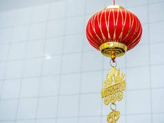 红色的中式吊灯挂在白色房间的背景上，带有复制空间，是中国新年的装饰品。1.灯笼上的文字是用来问安的.