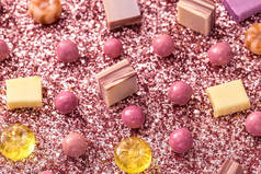 色彩艳丽的背景下的糖果和太妃糖，节日特写，亮晶晶的亮片和糖果