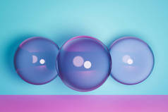 3D渲染。紫色充气球。排成一排的几何图形球的特写，粉色地板上有弹跳，蓝色背景