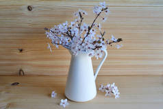 木制背景花瓶中的白梅花花束