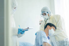 医生和护士穿着全身覆盖的衣服，在密室里照顾和帮助Covid-19感染病人.