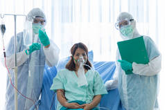 身穿防护服的医生正在医院隔离室内监测和检查感染CORONA VISRUS或COVID-19温度的病人。医生与病人合影.
