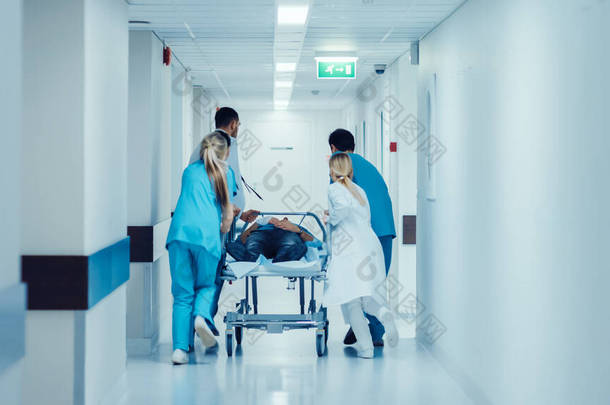 急诊部：医生、护士和医护人员将重伤员推入手术室。明快的现代化医院及医护人员拯救生命.