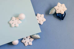 白色的雪花和球，银色的球果和灌木在蓝色的二色背景上。任何卡片邀请函、问候或任何目的的漂亮时髦设计. 
