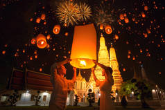 在泰国曼谷的阿伦庙会上，一对旅行的夫妇在清水的灯笼里欢欢喜喜地畅游着