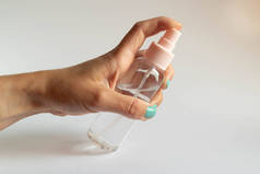 手拿着一个白色底座上有清澈液体的透明塑料喷雾瓶