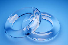 蓝色背景透明结婚戒指的3D图像。无限大符号中的环状几何形状.爱情和忠诚的象征，情人的结合