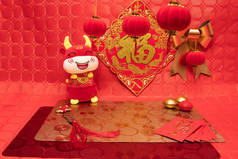 农历新年布置,以红、红为背景,以红银为装饰,以桌布和橘子为装饰,配以一头毛绒牛