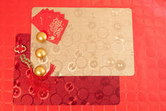 中国新年装饰用红色和金色饰品，红色桌上用红色和金色桌布点缀两支彩灯