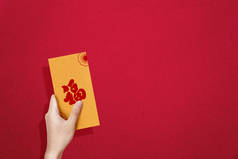 手持带有彩色背景的金信封（Angpao） 。新年快乐