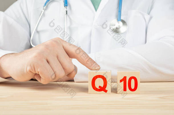 辅酶q10 。人体必需的维生素和矿物质。医生建议服用维生素q10 。医生谈论维生素q10的好处。维生素-健康概念。木材立方体上的q10字母表.
