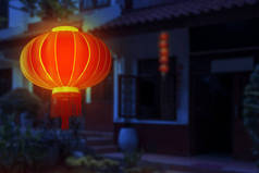 中国灯笼挂在房子前面，背景为夜景