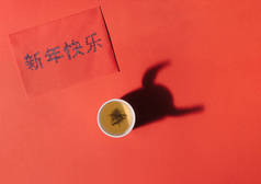 红外带绿茶的中国茶杯.用广东话写着新年快乐的红包。2021年牛角形状的阴影象征农历新年..