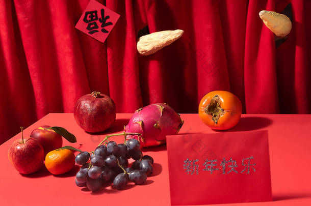 两只牛角突破了中国的红幕.粤语汉字的帷幕上写着好运浇灌 。红色桌子，各种新鲜水果，红色幸运信封新年快乐.