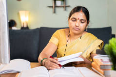 印度女教授通过在工作台上介绍家里的书籍来更正书籍的答题单