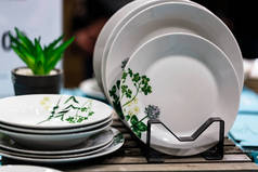 空的白色盘子。把碗碟放在木制桌子上.奢华的晚餐,洁白的套餐,精致的瓷盘.餐桌布置。白盘叠得整整齐齐.有选择的重点。任何设计的复制空间.