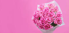 粉红色背景上的一束粉红色玫瑰，一面横幅