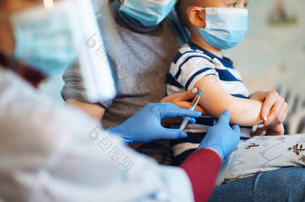 人民免疫概念免疫健康。Covid-19 。儿童医生在家里给小男孩接种疫苗。保健、验尸、预防和免疫.