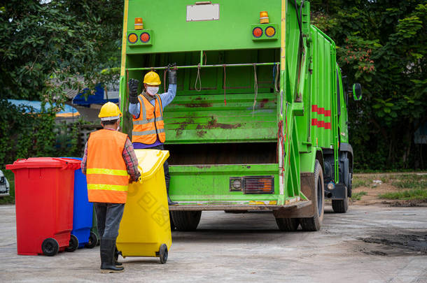 垃圾收集服务、穿着制服的垃圾清洁工人携手合作，把垃圾倒空，再用卡车装运废物及<strong>垃圾桶</strong>作垃圾处理。废物回收概念.