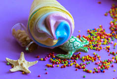 色彩艳丽的雪糕在华夫饼杯里，一只乌龟和一只海星在紫色的背景上平平淡淡的。2021年夏天流行的色彩- -淡蓝色、粉色、黄色。高热量美味的甜食。夏季食品概念