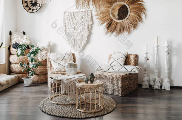 家居装饰的概念。舒适的柳条家具、<strong>坐垫</strong>藤椅、竹子咖啡桌，以及舒适室内设计的白色墙壁上的石榴