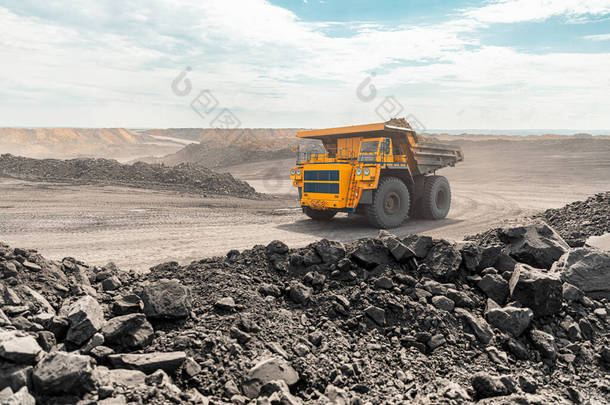 大型采石场垃圾车。大型黄色矿用卡车在工地。把煤装进货车里.生产有用矿物。露天采煤用矿用卡车采矿机械