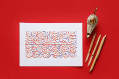 带有阿拉伯文文本和彩色背景书法工具的纸张