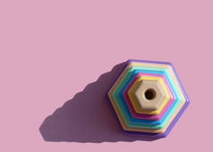 儿童玩具建造者金字塔鲱鱼骨在粉红的背景上涂上柔和的颜色。简约主义、影子