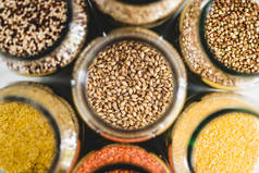 大麦和其他健康的全麦和豆类食品，放在大理石背景的透明食品罐中，简单素食食品配料概念，简单素食食品配料概念