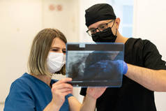Two doctors checking x-ray image in hospital, high quality photo 