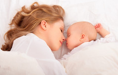 睡在一起。母亲拥抱新生婴儿躺在床上