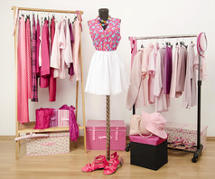 更衣室衣柜用粉色的衣服，安排在衣架和模特儿身上的衣服.