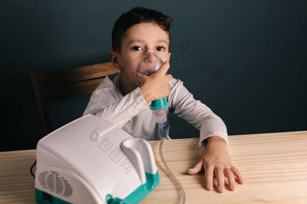 美丽生病的男孩吸入疗法由吸入的掩<strong>码</strong>。一个可爱的小孩，与呼吸问题或哮喘的形象。烟雾从氧气面罩雾化器的视图