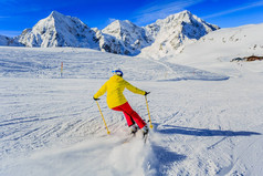 在山上一个晴朗的日子, 女人在雪地上滑雪。滑雪赢