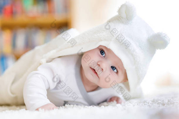 宝贝女孩穿着白色毛巾或冬季总体在白色阳光明媚的卧室里