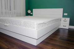 卧室里的白色大床。卧室的内部。白色绿色卧室
